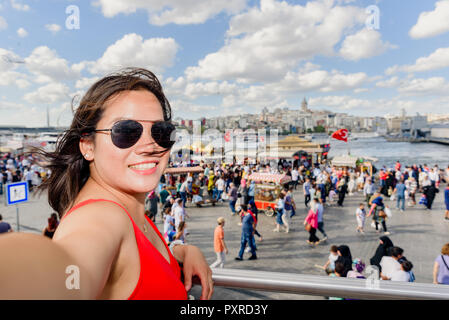 Belle femme chinoise pose avec vue sur la Tour de Galata au district d'Eminonu à Istanbul, Turquie Banque D'Images