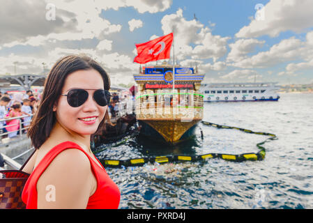 Belle femme chinoise se place en avant des navires historiques à Eminonu Istanbul,Turquie,Ville Banque D'Images