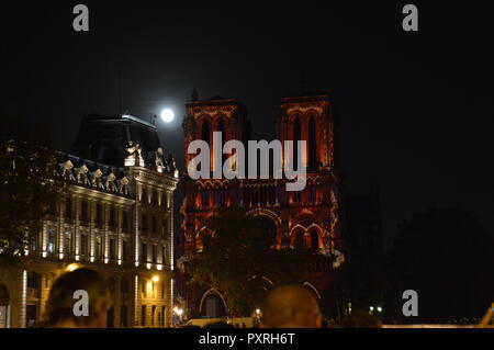 Cathédrale Notre-Dame de Paris, France. 23 Oct 2018. Parisiens et profiter de l'animation de l'hologramme sur la façade de la cathédrale Notre-Dame de Paris.(du vrai pleine lune en arrière-plan). 23 octobre. 19h30 ALPHACIT NEWIM / Alamy Live News Crédit : Alphacit NEWIM/Alamy Live News Banque D'Images