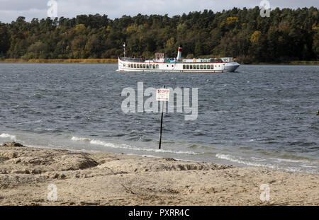 Waren, Allemagne. 22 octobre, 2018. Le lieu de baignade Ecktannen an der Müritz est sec, un panneau pour avertir les non-nageurs est presque à sec elle-même. La sécheresse prolongée a entraîné des niveaux d'eau dans les lacs du Mecklembourg à chuter de près de 70 centimètres. La situation n'est pas encore une menace pour les grands lacs. Dans les petits lacs et rivières, d'autre part, les poissons peuvent mourir dans l'hiver s'il y a un couvert de glace. Crédit : Bernd Wüstneck/dpa/Alamy Live News Banque D'Images