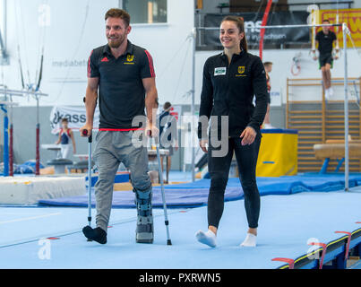 17 octobre 2018, Saxe, Chemnitz : High bar spécialiste Andreas Bretschneider va à des aides à la marche à côté de Pauline Schäfer, champion du monde à la poutre, à travers le gymnase dans le Sportforum Chemnitz. Les gymnastes haut de Chemnitz Mlle le championnat du monde à Doha en raison de blessures. Schäfer souffre encore d'une blessure à la cheville. Bretschneider déchira ses le tendon d'Achille dans son pied gauche au championnat allemand de Leipzig. (Dpa-message : 'Sannonce paire de gymnastes : Bergers et aux Championnats du monde l'expérience Bretschneider avant TV' à partir de 24.10.2018) Photo : Hendrik Schmidt/dpa-Zentralbil Banque D'Images