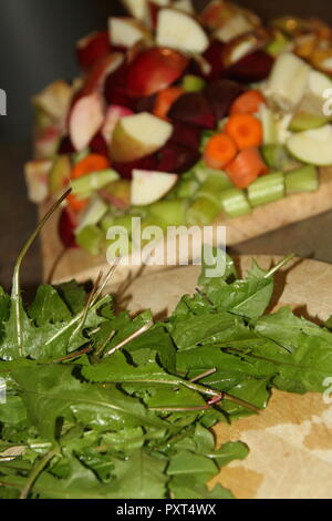 Les feuilles de pissenlit et de fruits et légumes sur des planches Banque D'Images