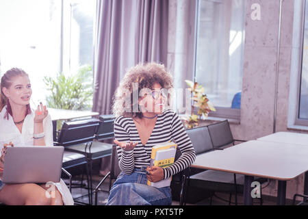 Plaisir positif international female holding her books Banque D'Images