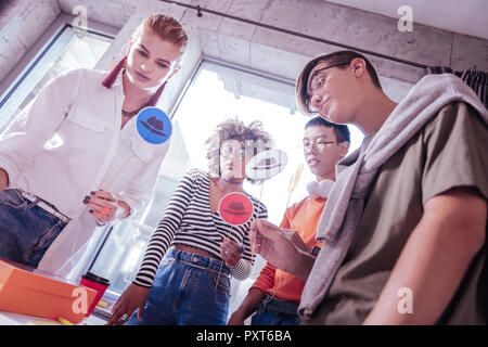 Les jeunes concentrés autour d'une table avec photo Banque D'Images