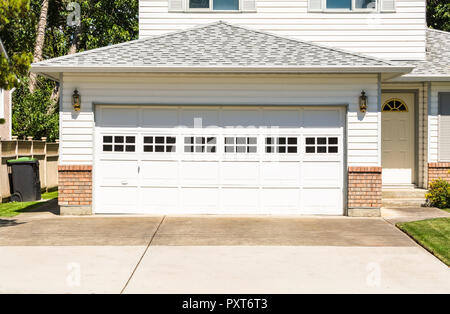 Un quartier idéal. Maison de famille avec grande porte de garage et l'allée en béton à l'avant Banque D'Images