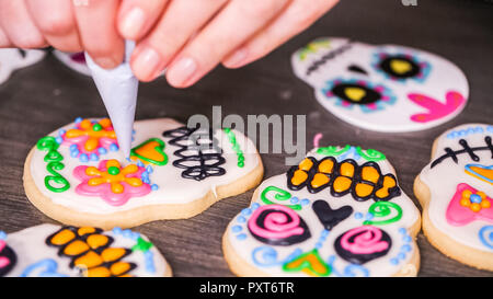 Étape par étape. La décoration de crâne en sucre cookies avec des couleurs de glaçage royal. Banque D'Images