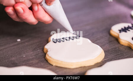 Étape par étape. La décoration de crâne en sucre cookies avec des couleurs de glaçage royal. Banque D'Images