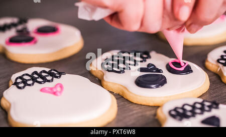 Étape par étape. La décoration de crâne en sucre cookies avec des couleurs de glaçage royal. Banque D'Images
