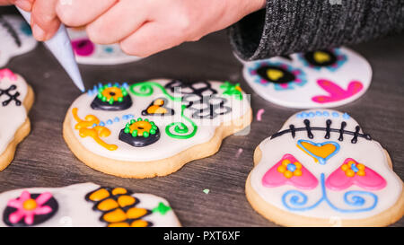 Étape par étape. La décoration de crâne en sucre cookies avec des couleurs de glaçage royal. Banque D'Images