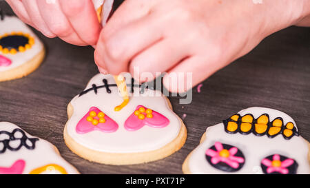 Étape par étape. La décoration de crâne en sucre cookies avec des couleurs de glaçage royal. Banque D'Images