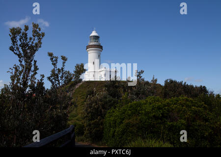 Un phare blanc sur le sommet d'une colline verte et abondante en Australie. Un escalier peut être vu à gauche de l'image vers l'immeuble. Banque D'Images