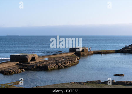 Estoril, Portugal - Juillet 9, 2018 : Deux jeunes hommes se baigner dans l'eau de mer extérieure à côté de l'Atlantique, près de la promenade à Estoril au Portugal Banque D'Images