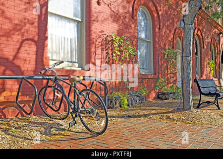 Au début de l'automne dans l'Ohio, Wiloughby scène où un seul vélo est garé à côté d'un bâtiment orange russet avec une poignée de feuilles mortes. Banque D'Images