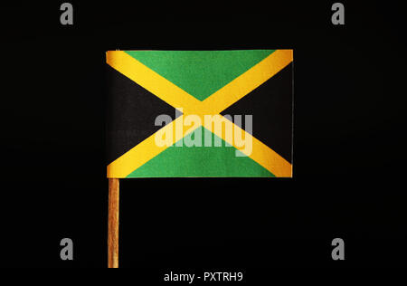 Un drapeau original et officiel de la Jamaïque le cure-dent et sur fond noir. La Jamaïque situé dans l'Amérique centrale. Il sait que la terre de la lutte contre les mauvaises herbes Banque D'Images