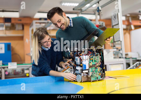 Les jeunes élèves de mécatronique attrayant de travailler sur projet Banque D'Images