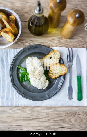 Tresse de mozzarella, basilic et le pain sur la plaque Banque D'Images