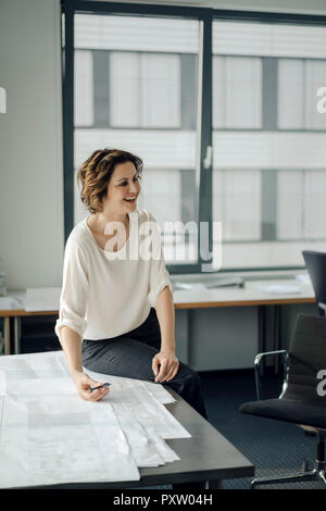 Businesswoman sitting in office, travaillant sur les bleus Banque D'Images