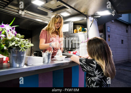 Jeune femme dans un camion alimentaire au service client Banque D'Images