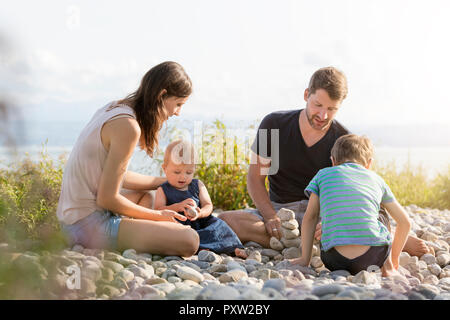 Allemagne, Lac de Constance, Friedrichshafen, jouant avec des pierres au Lakeshore Banque D'Images