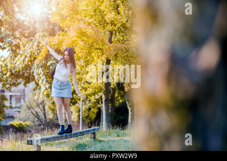 Young woman balancing on wood Banque D'Images