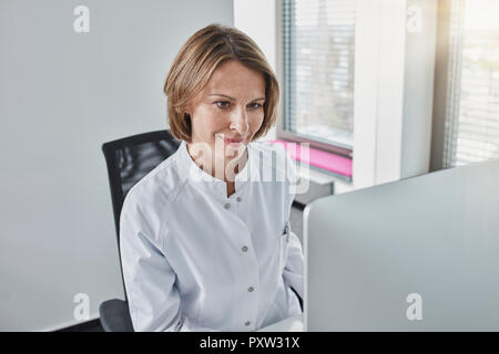 Femme médecin travaillant sur ordinateur Banque D'Images