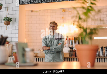 Jeune homme qui travaille dans son café de start-up, portrait Banque D'Images