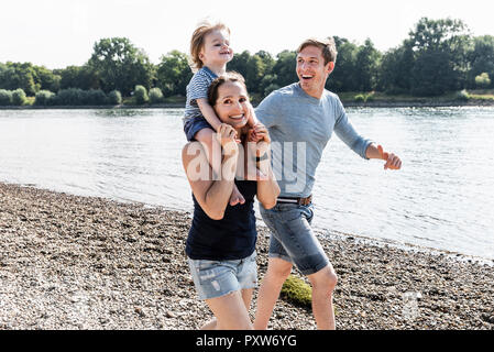 Famille heureuse balade au bord du fleuve sur une belle journée d'été Banque D'Images