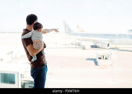 Espagne, Barcelone, Man holding a baby girl à l'aéroport en montrant les avions Banque D'Images