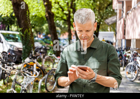 Mature man using cell phone in the city Banque D'Images