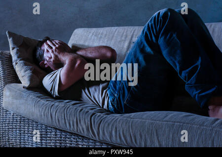 Lumière dramatique vie portrait de jeune homme triste et déprimé qui sont à la table d'accueil ombragé dans la douleur et la dépression Le stress et désespérément mon vieux copain Banque D'Images