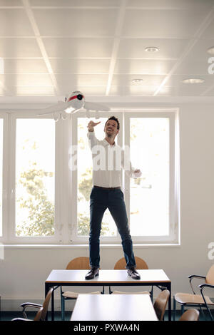 Businessman Playing with inflatable airplane in office Banque D'Images