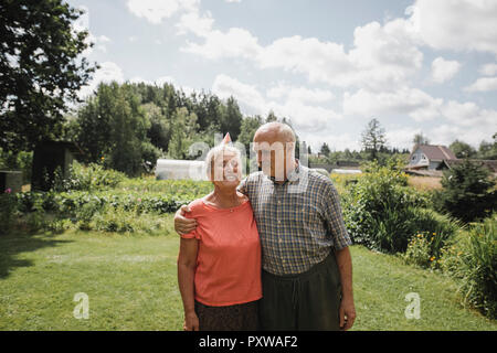 Happy senior couple debout dans le jardin Banque D'Images