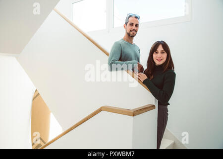Business couple debout sur l'escalier menant à leur bureau Banque D'Images