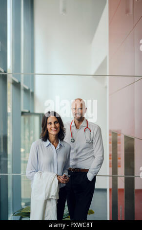 Friendly doctors standing in hospital, smiling Banque D'Images