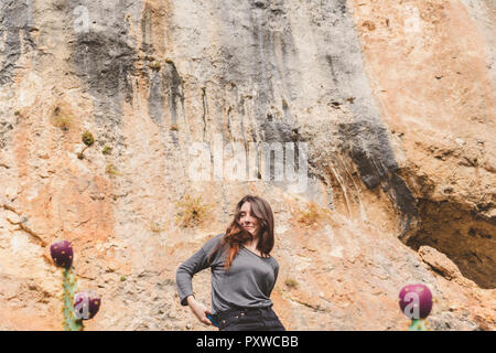 L'Espagne, Alquezar, portrait of smiling young woman in front of rock face Banque D'Images