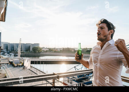 Happy businessman sitting on, boire de la bière Banque D'Images