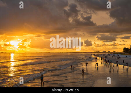 États-unis d'Amérique, Floride, Fort Myers, silhouettes de Fort Myers Beach et les touristes avec un énorme nuage de pluie au-dessus pendant le coucher du soleil Banque D'Images