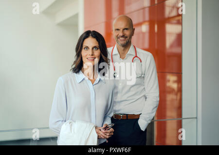 Friendly doctors standing in hospital, smiling Banque D'Images