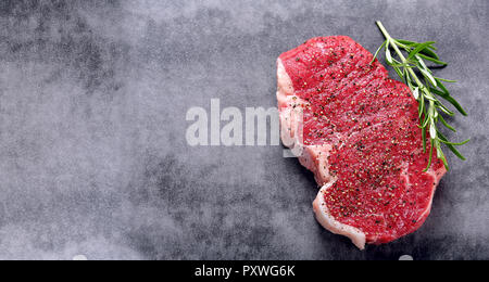Steak cru avec des épices sur un fond de pierre avec l'espace vide pour le texte Banque D'Images