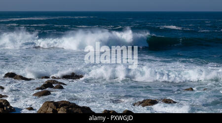 Casser vagues ondulantes d'une mer bleu vif et blanc de mousse sur la plage rocheuse de surf à SEnnen Cove, Cornwall dans le soleil. Banque D'Images