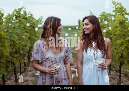 Les jeunes femmes walkig en vignoble, un pique-nique, boire du vin Banque D'Images