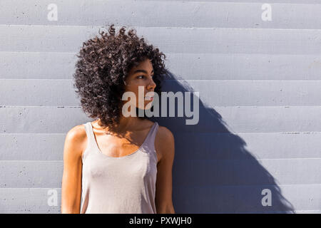 Jeune femme avec des cheveux bouclés en attente Banque D'Images