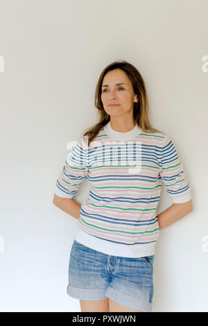Portrait of mature woman leaning against a wall Banque D'Images