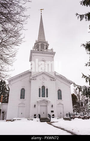 Première église presbytérienne, bâtiment historique à steeple blanc surmonté de poissons dorés weathervane, entourée de neige et d'arbres à feuilles persistantes à Cazenovia, NY Banque D'Images