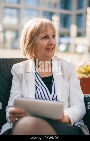 Senior businesswoman est assis dans un café et la recherche d'emploi sur internet. Banque D'Images