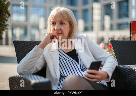 Senior businesswoman est assis dans un café et la recherche d'emploi sur internet. Banque D'Images