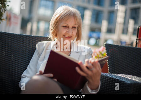 Senior businesswoman est assis dans un café et faire de plans pour l'emploi. Banque D'Images