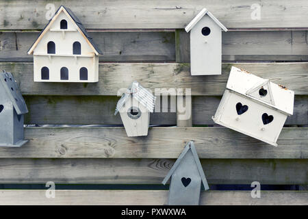 Maisons d'oiseaux en bois avec des trous en forme de coeur sur une clôture en bois Banque D'Images