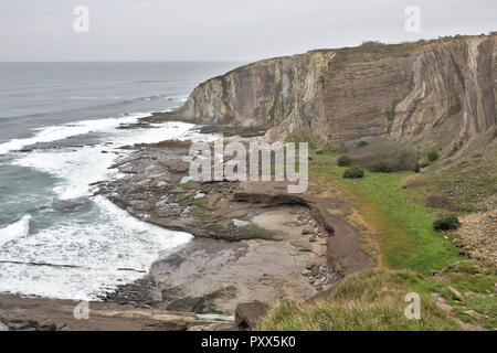 Un paysage des hautes falaises humides, sur une mer déchaînée pendant un jour de pluie nuageux du Paseo de las Palmeras à Getxo ville, dans le Pays Basque, Espagne Banque D'Images