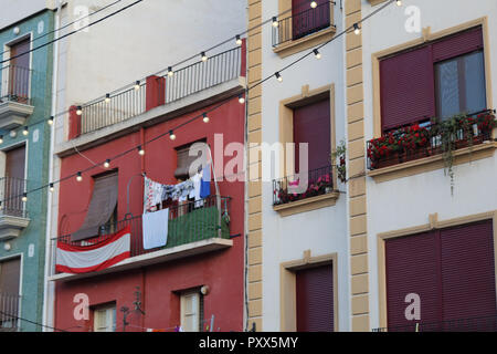 Sud de l'Espagne moderne typique des maisons avec un drapeau de l'Espagne, quelques vêtements et de séchage pendaison lumières dans les rues de Orihuela, Espagne Banque D'Images